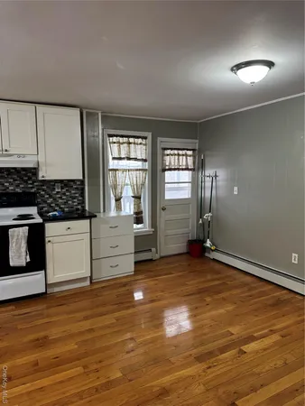 a view of a kitchen with wooden floor and electronic appliances