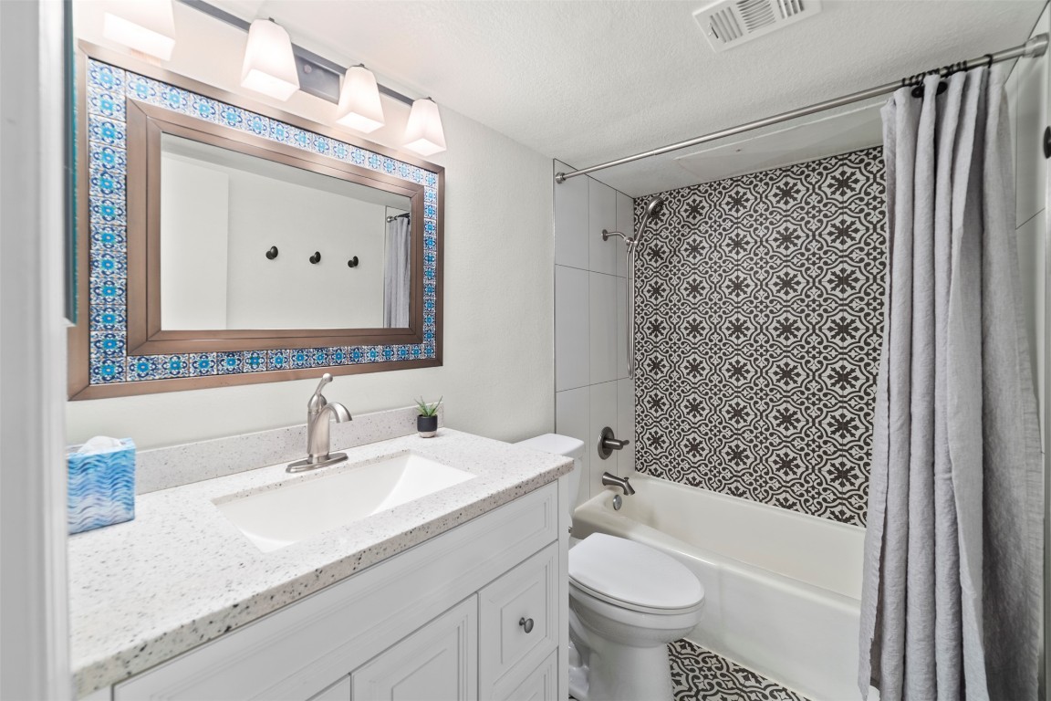 505 West 7th Street, Unit 113 Austin, TX 78701 - Photo 12 of 26 a bathroom with a granite countertop sink toilet mirror and shower