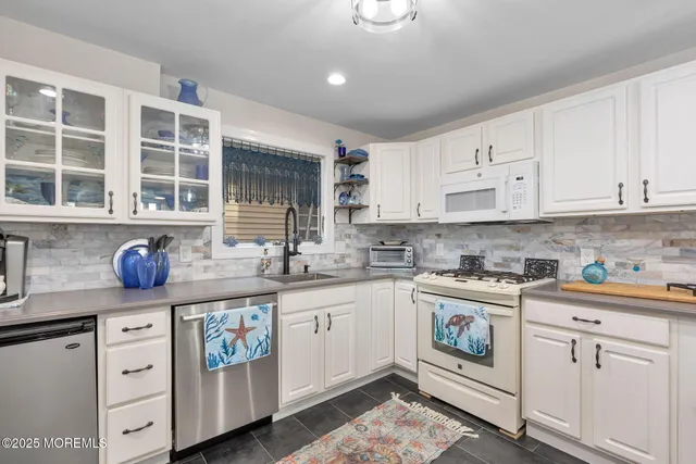 a kitchen with granite countertop cabinets stainless steel appliances and a sink