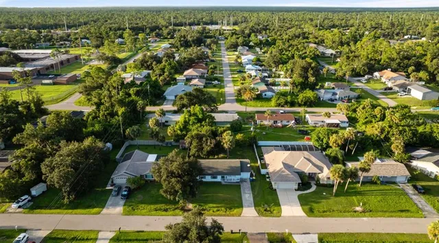 an aerial view of residential houses with outdoor space and swimming pool