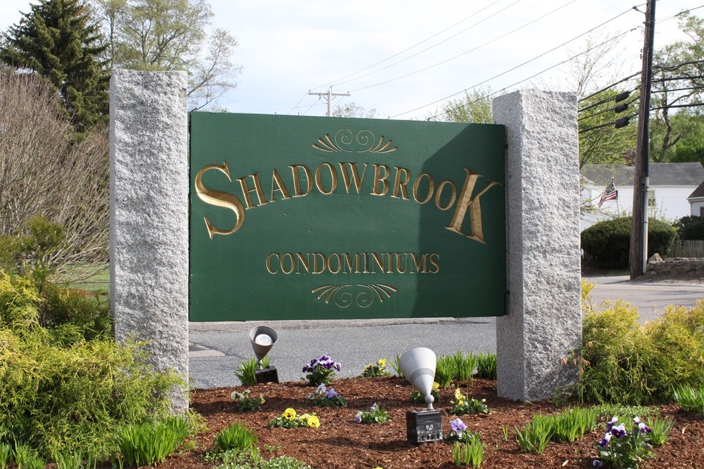 10 Shadowbrook Lane, Unit 19 Milford, MA 01757 - Photo 2 of 22 a sign that is sitting on a brick wall