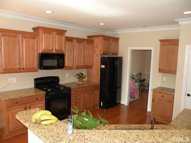 a kitchen with stainless steel appliances granite countertop a refrigerator stove and sink
