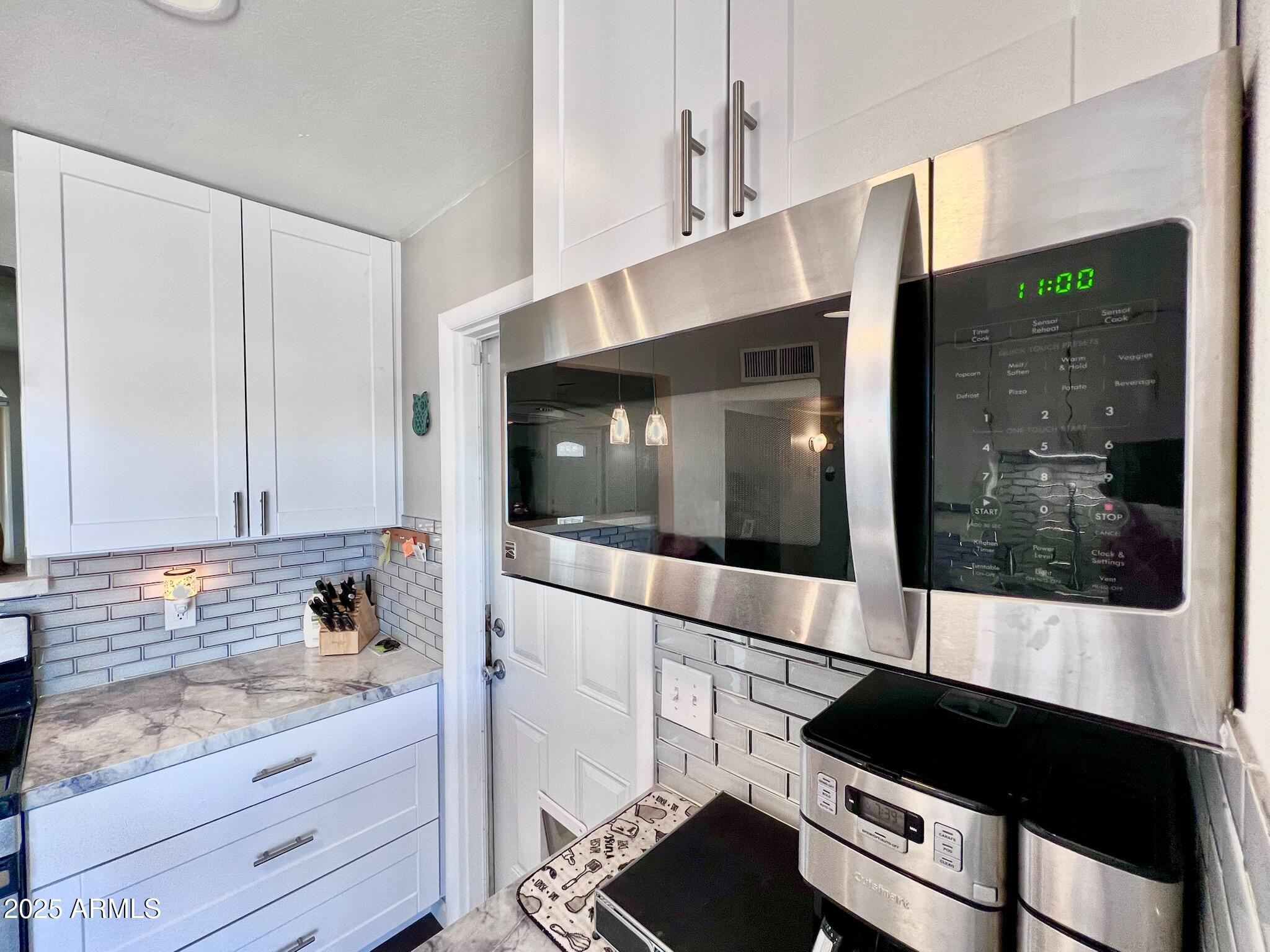 3328 West Charter Oak Road Phoenix, AZ 85029 - Photo 1 of 39 a kitchen with granite countertop white cabinets and black appliances