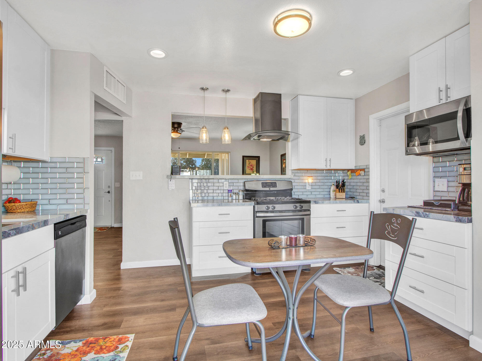 3328 West Charter Oak Road Phoenix, AZ 85029 - Photo 11 of 39 a kitchen with stainless steel appliances kitchen island granite countertop a dining table and chairs in it