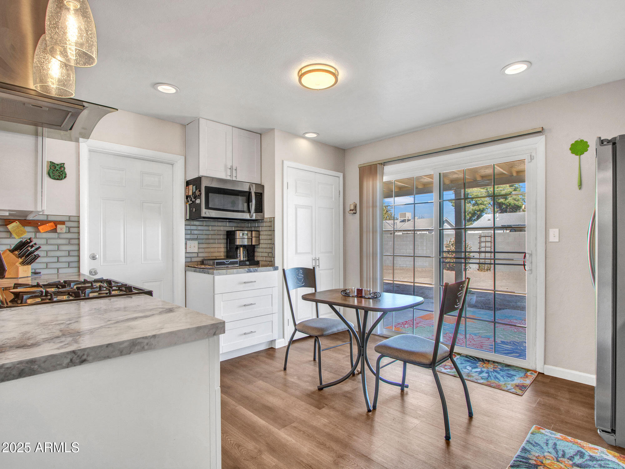 3328 West Charter Oak Road Phoenix, AZ 85029 - Photo 13 of 39 a view of a dining room with furniture a chandelier and wooden floor