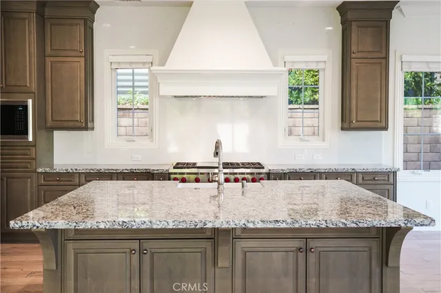 a kitchen with granite countertop a sink a window and stainless steel appliances