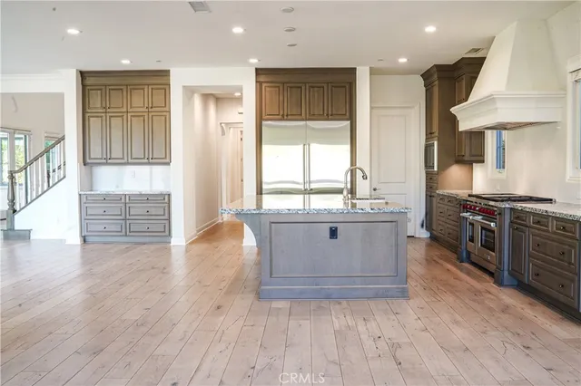 a kitchen with stainless steel appliances granite countertop a stove a sink and a refrigerator
