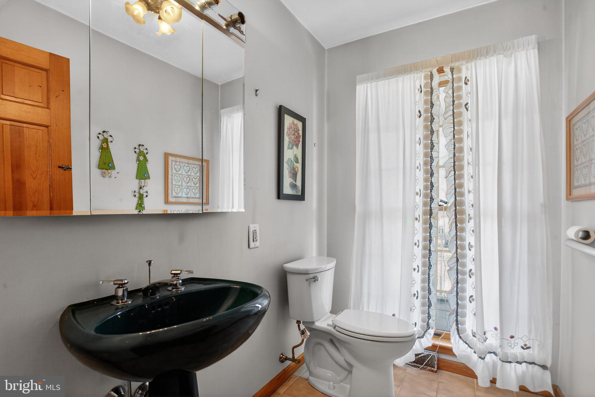 4508 Benson Street Philadelphia, PA 19136 - Photo 14 of 26 a bathroom with a sink a toilet and a mirror
