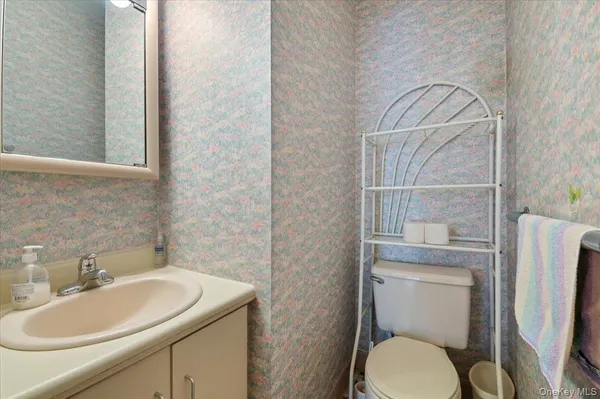 a bathroom with a toilet sink vanity and mirror
