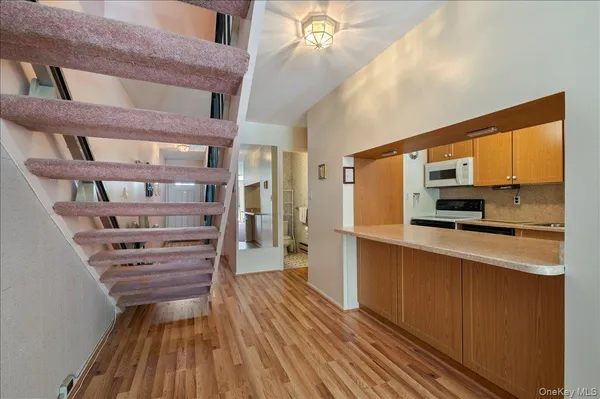 a view of a kitchen with kitchen island granite countertop wooden floors and a sink