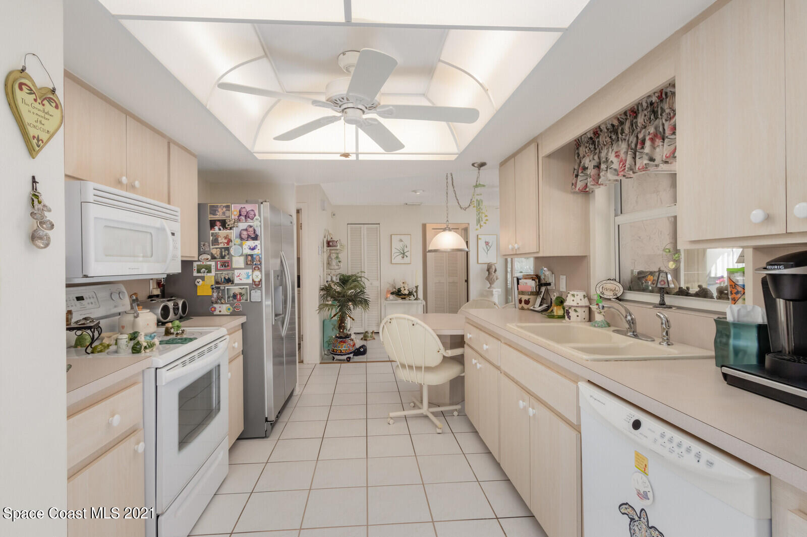 1953 Trimble Road Melbourne, FL 32934 - Photo 17 of 70 a large white kitchen with a stove a sink a refrigerator and chandelier