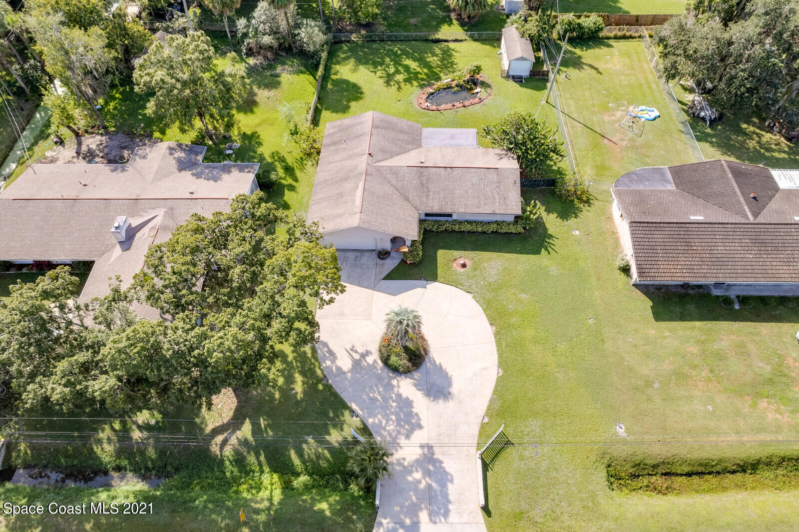 1953 Trimble Road Melbourne, FL 32934 - Photo 39 of 70 a aerial view of a house with swimming pool and large trees