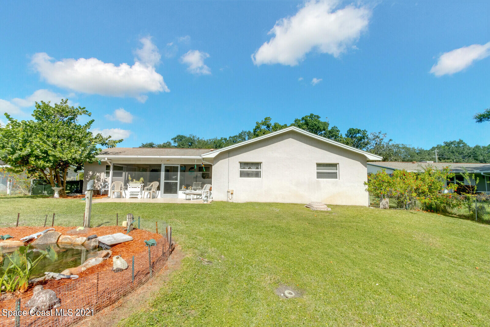 1953 Trimble Road Melbourne, FL 32934 - Photo 6 of 70 a view of a house with a big yard and potted plants