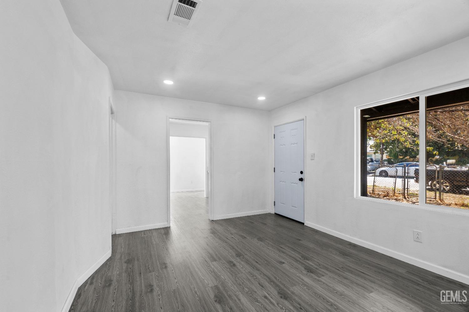 Undisclosed Address Bakersfield, CA 93307 - Photo 11 of 15 a view of an empty room with wooden floor and a window