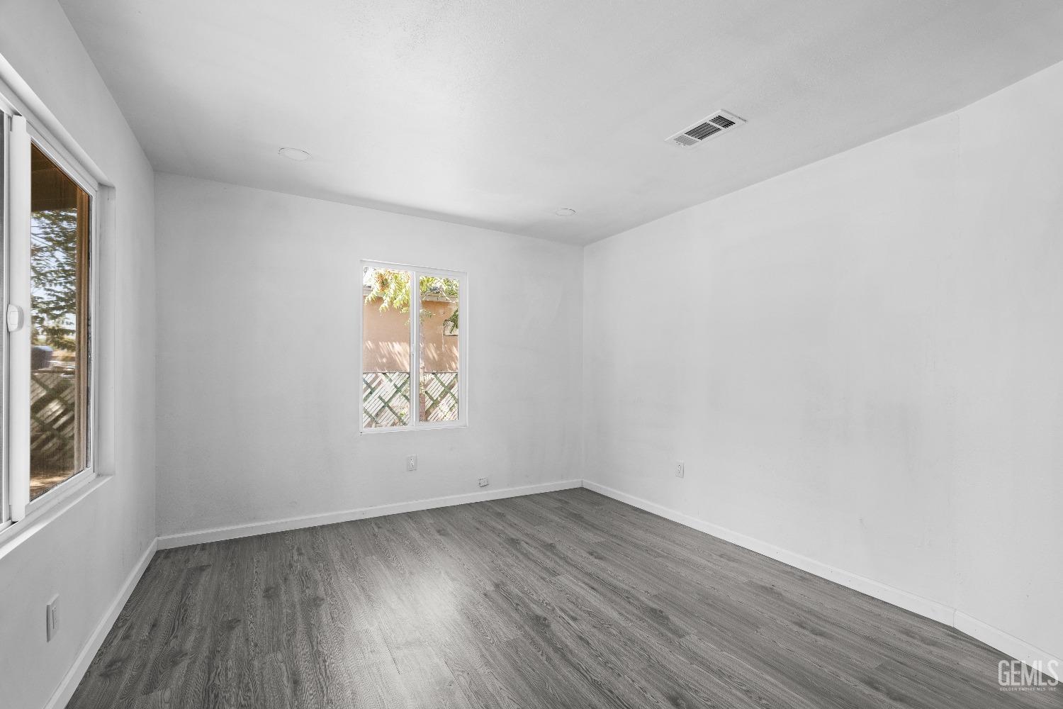Undisclosed Address Bakersfield, CA 93307 - Photo 12 of 15 an empty room with wooden floor and window