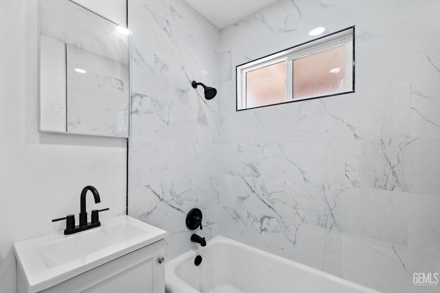 Undisclosed Address Bakersfield, CA 93307 - Photo 6 of 15 a bathroom with a tub sink and mirror