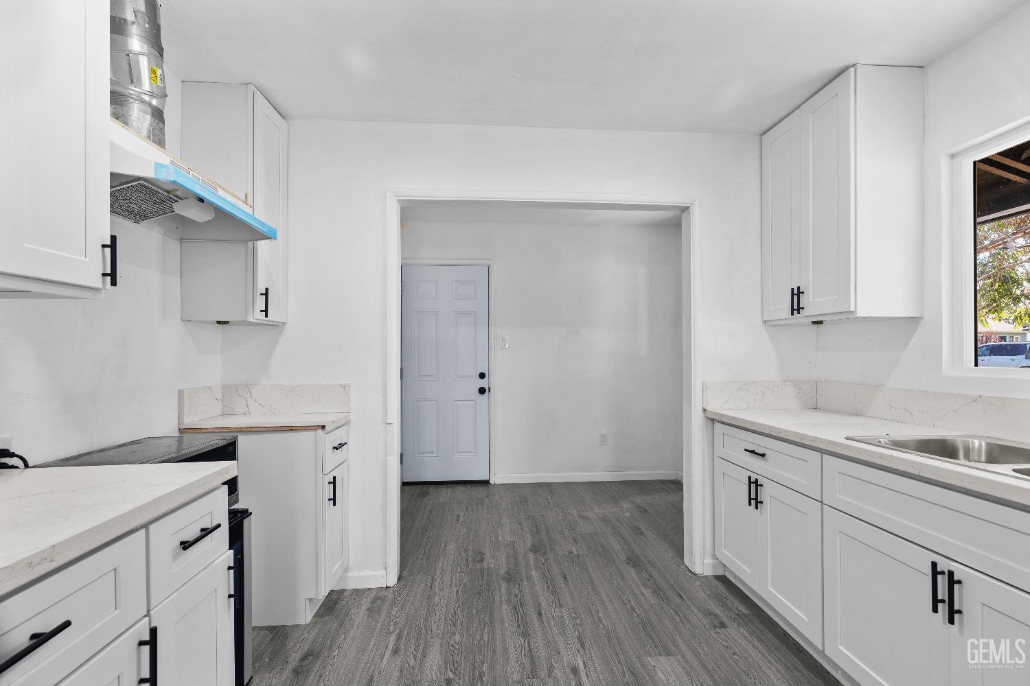 Undisclosed Address Bakersfield, CA 93307 - Photo 9 of 15 a kitchen with a sink cabinets and wooden floor