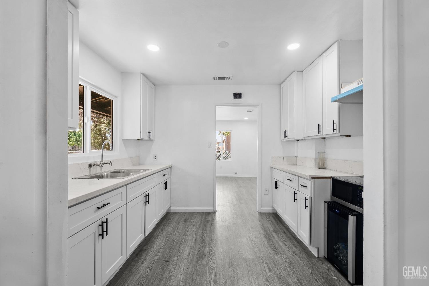 Undisclosed Address Bakersfield, CA 93307 - Photo 10 of 15 a kitchen with granite countertop a sink and cabinets with wooden floor