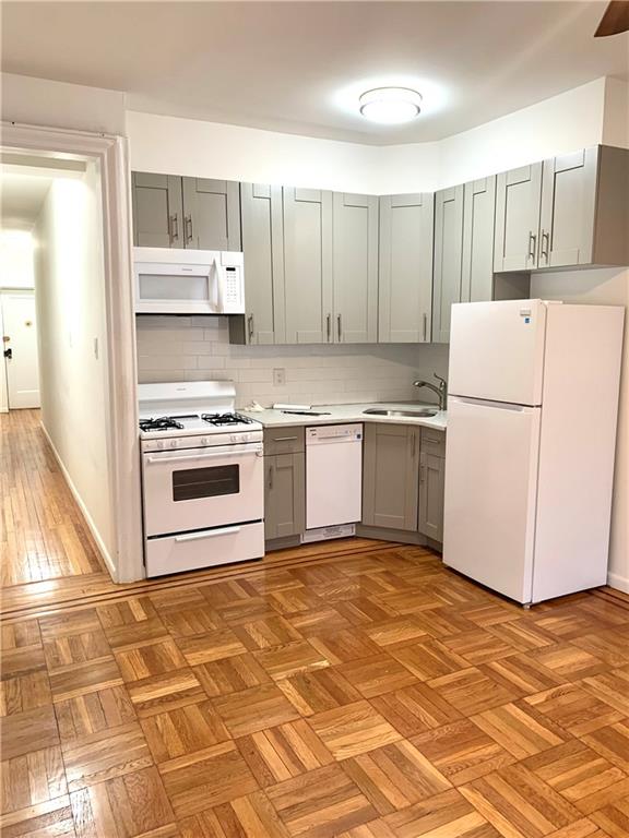 402 Bay Ridge Parkway, Unit 5 Brooklyn, NY 11209 - Photo 5 of 14 a kitchen with a stove a refrigerator and white cabinets