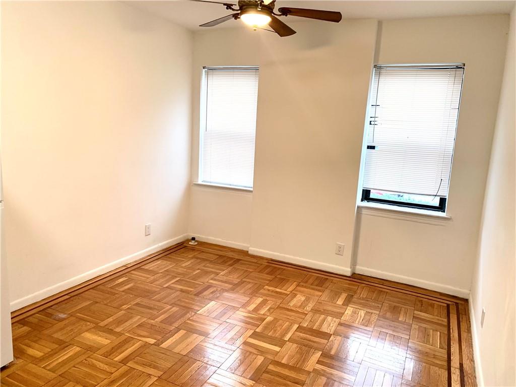 402 Bay Ridge Parkway, Unit 5 Brooklyn, NY 11209 - Photo 10 of 14 an empty room with a chandelier fan and windows