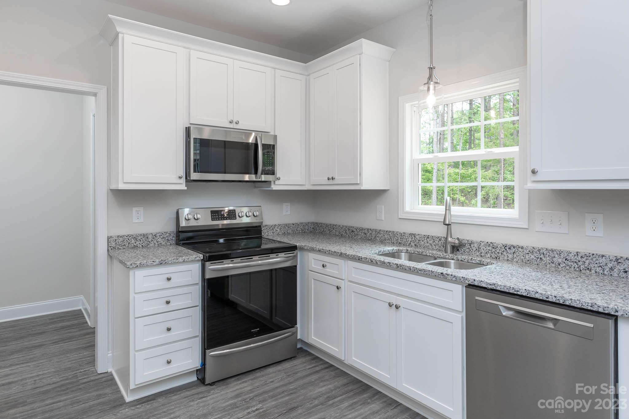 4420 Culp Road Edgemoor, SC 29712 - Photo 3 of 25 a kitchen with granite countertop white cabinets appliances a window and a sink
