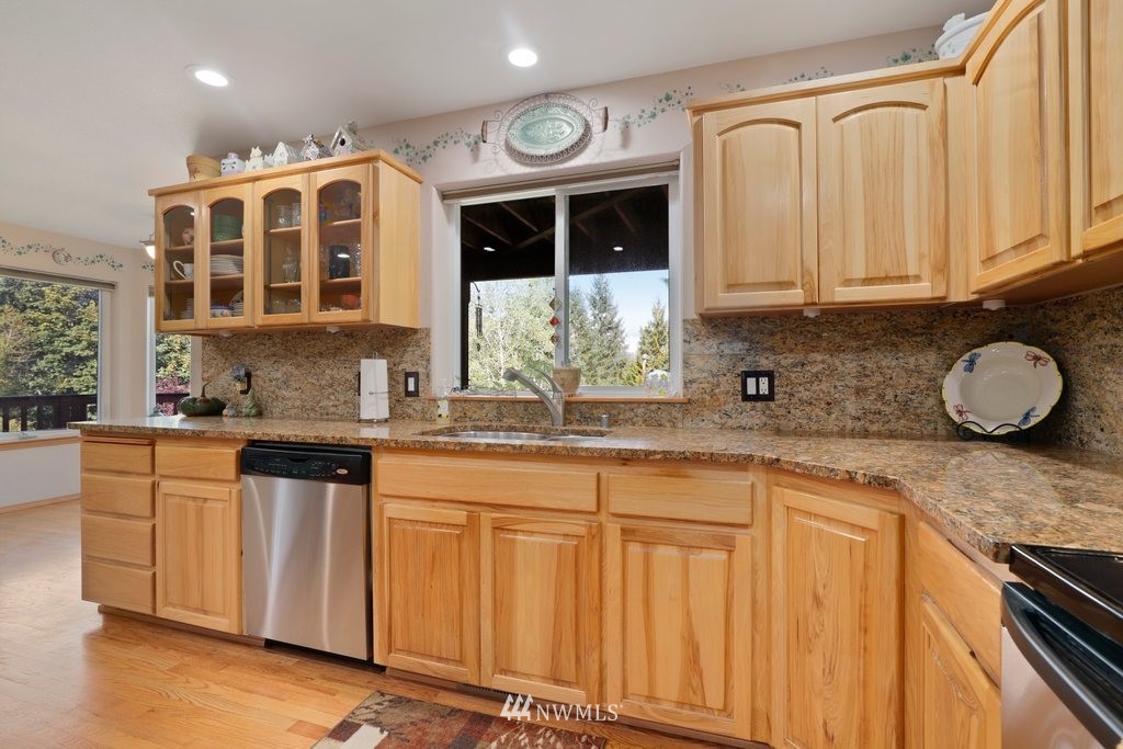 10606 Wagner Road Snohomish, WA 98290 - Photo 11 of 40 a kitchen with stainless steel appliances granite countertop a sink and cabinets with wooden floor