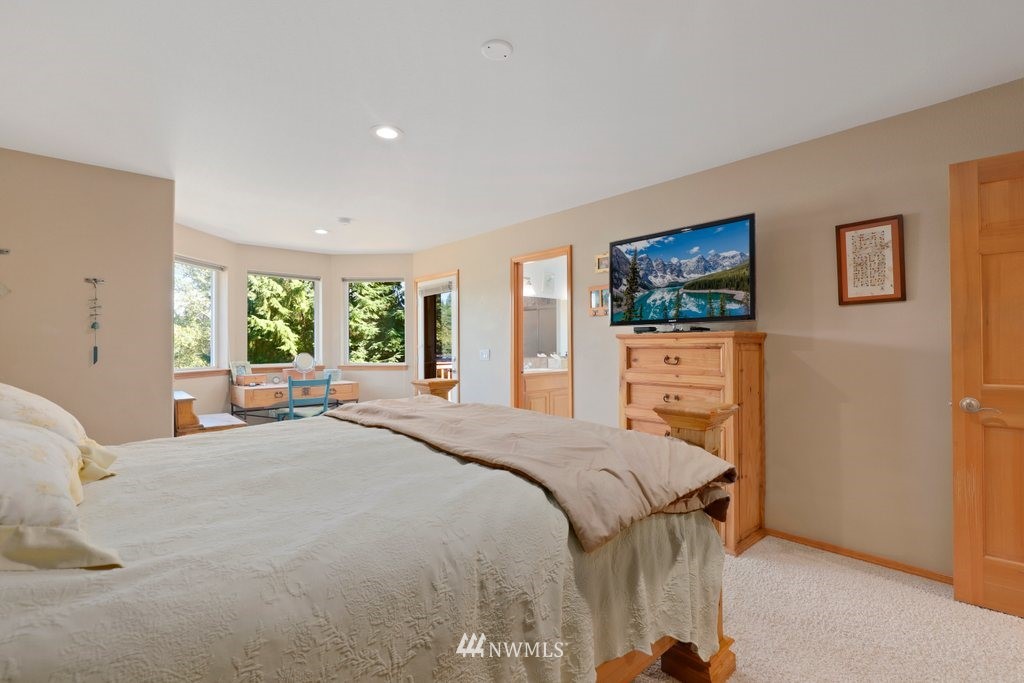 10606 Wagner Road Snohomish, WA 98290 - Photo 22 of 40 a bedroom with a bed and a flat screen tv