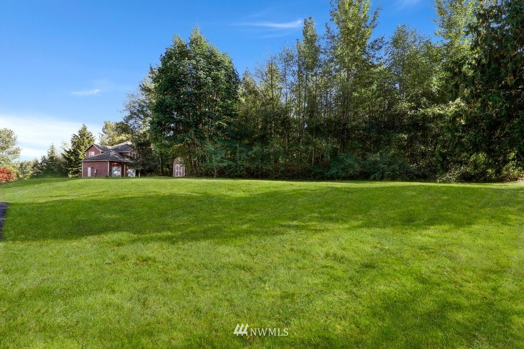 10606 Wagner Road Snohomish, WA 98290 - Photo 37 of 40 a view of a grassy field with trees in the background