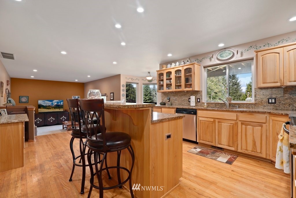 10606 Wagner Road Snohomish, WA 98290 - Photo 10 of 40 a kitchen with stainless steel appliances kitchen island granite countertop a table chairs and a refrigerator