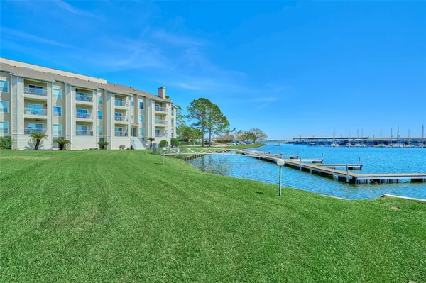 a view of a house with a big yard and large trees