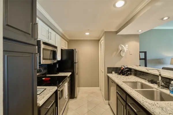 a kitchen that has a sink a refrigerator and cabinets