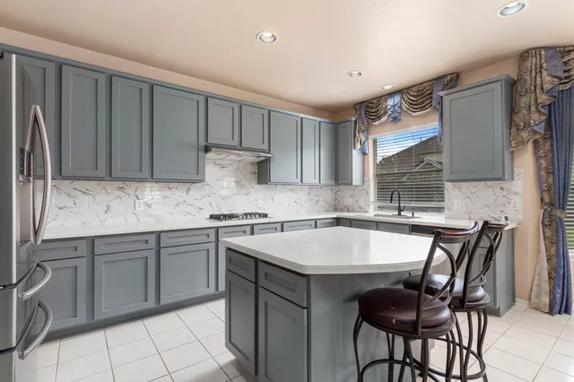 a kitchen with a refrigerator a stove a sink and cabinets