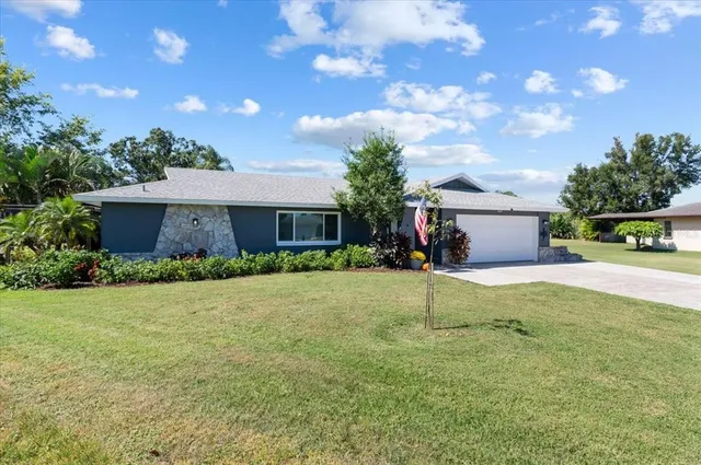 a view of a house with a big yard and large tree