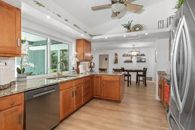 a kitchen with granite countertop a sink a counter space appliances and cabinets