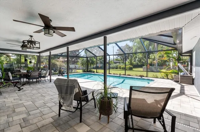 a view of a dining room with furniture large windows and a chandelier