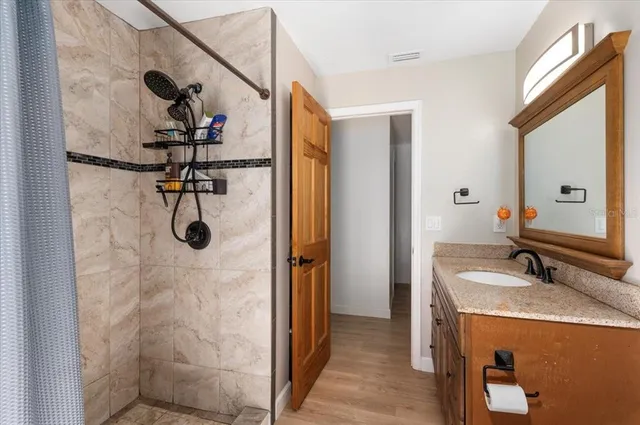 a bedroom with furniture a flat screen tv and a window