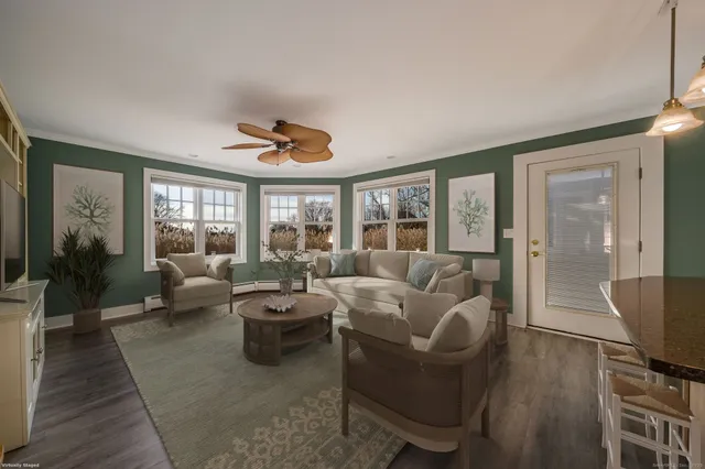 a living room with furniture a flat screen tv and a large window