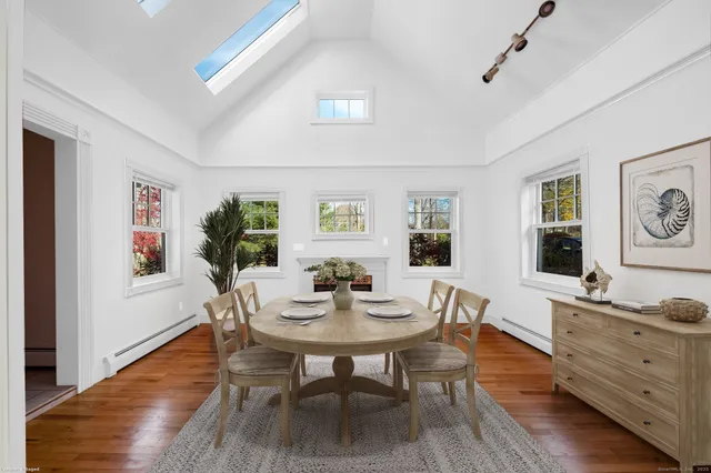 a dining room with furniture window and wooden floor