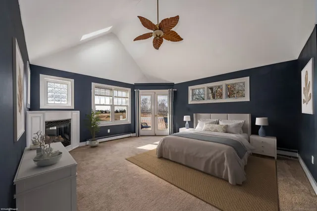 a spacious bedroom with a bed a couch and a fireplace