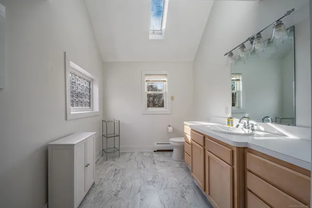 a bathroom with a sink a toilet and a mirror