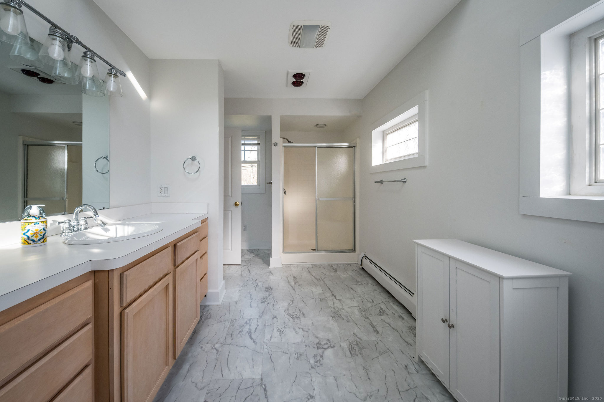 90 Boston Post Road Madison, CT 06443 - Photo 30 of 38 a bathroom with a sink a mirror and a shower