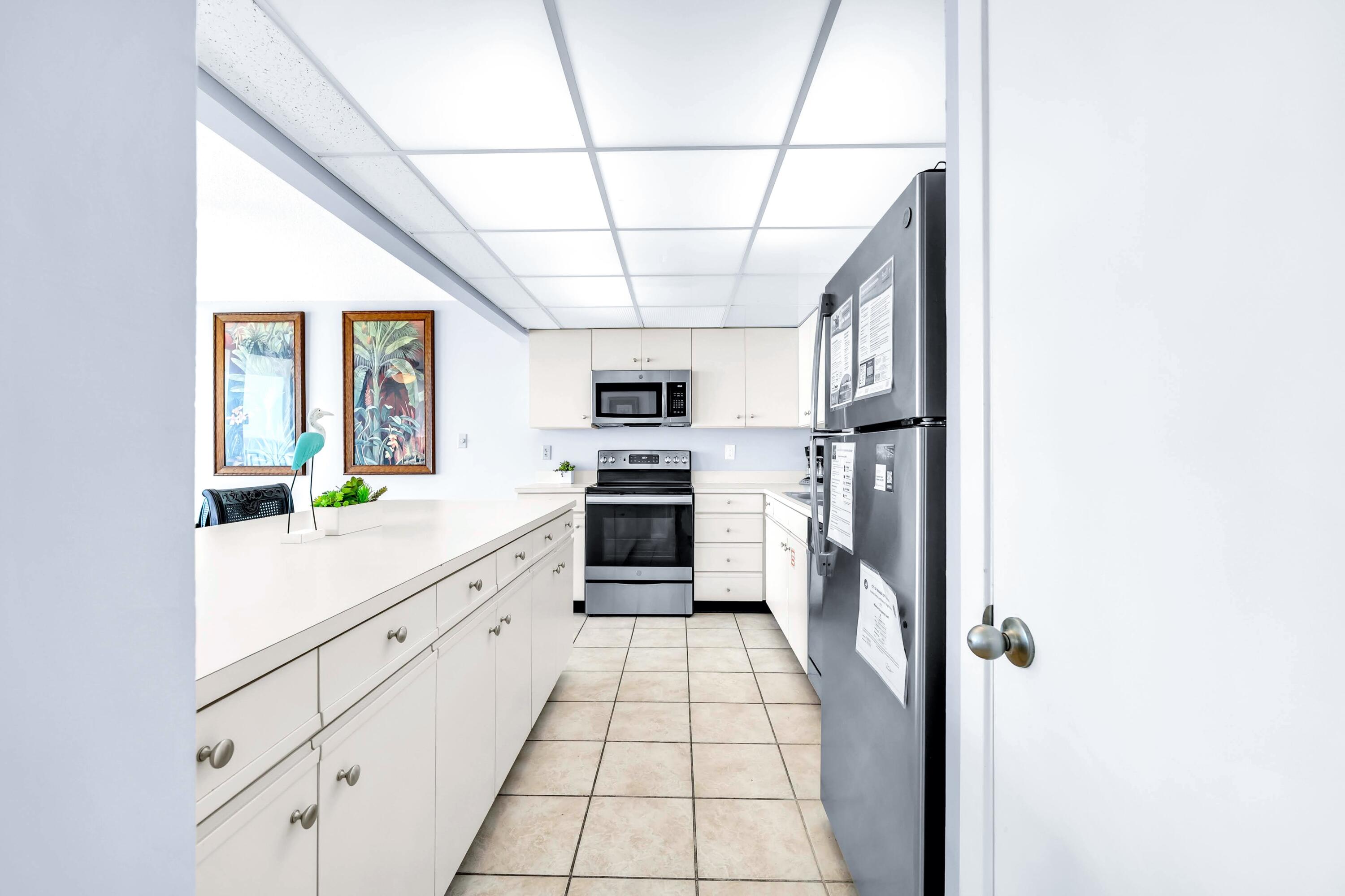 11619 Front Beach Road, Unit 307 Panama City Beach, FL 32407 - Photo 11 of 48 a kitchen with stainless steel appliances kitchen island granite countertop a refrigerator and a stove top oven