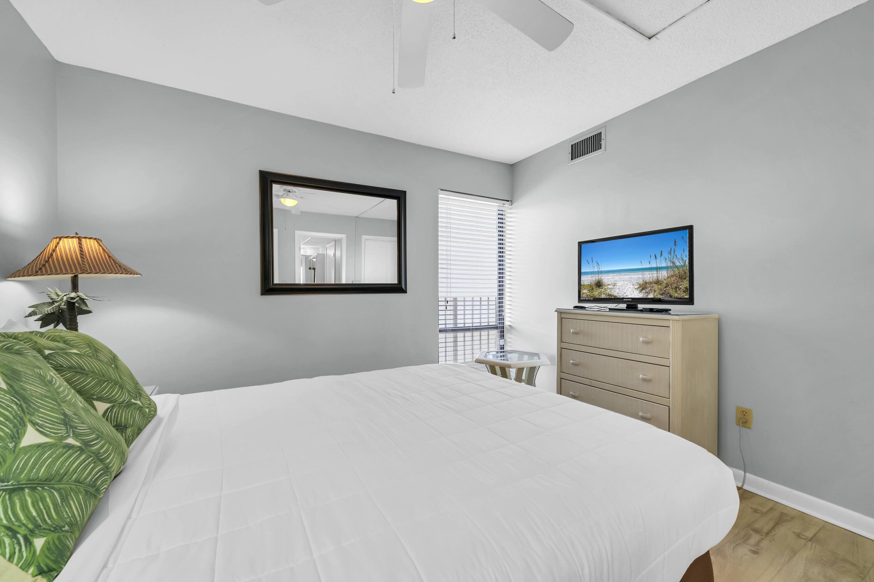 11619 Front Beach Road, Unit 307 Panama City Beach, FL 32407 - Photo 14 of 48 a bedroom with a bed and a television