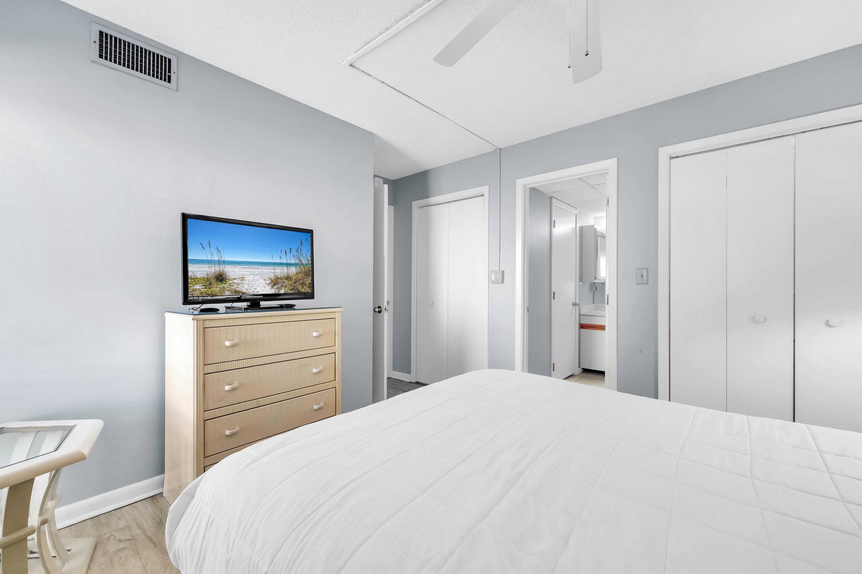 11619 Front Beach Road, Unit 307 Panama City Beach, FL 32407 - Photo 15 of 48 a bedroom with a bed and a flat screen tv