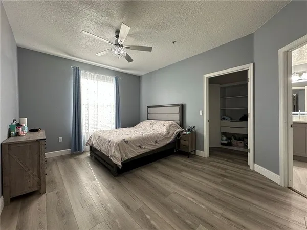 a bedroom with a bed and a ceiling fan