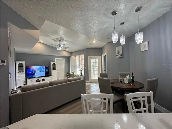 a living room with furniture kitchen and a chandelier