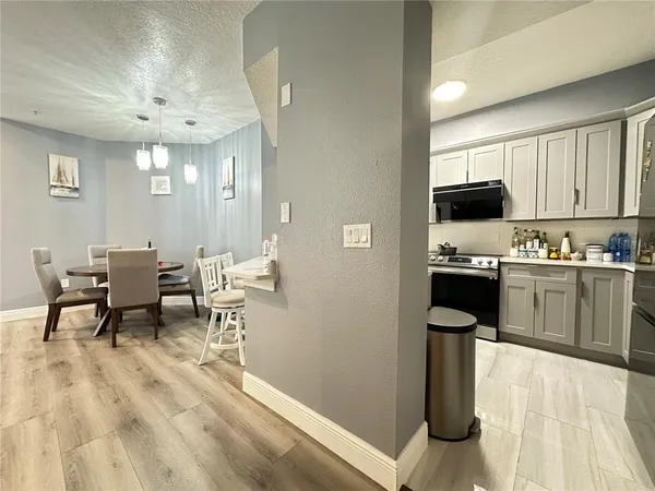 a kitchen with stainless steel appliances granite countertop a stove refrigerator and a dining table with wooden floor