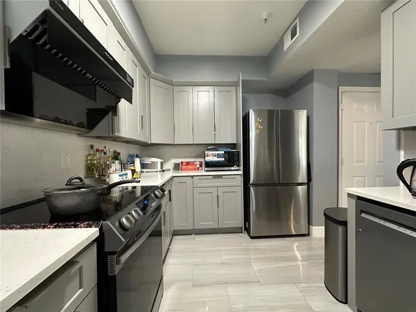 a kitchen with a refrigerator stove and cabinets