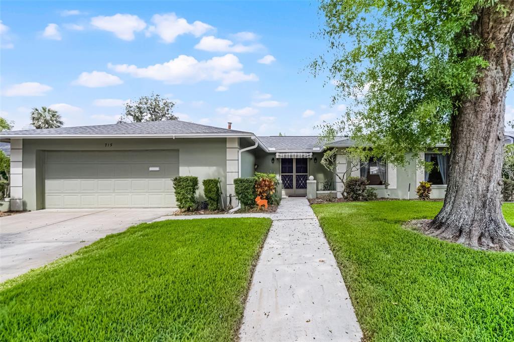 a front view of a house with a yard and trees