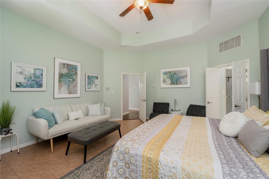 135 Kirkpatrick Road Ennis, TX 75119 - Photo 17 of 40 a bedroom with a bed a couch and a chandelier